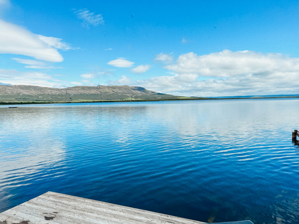 Lake Laugarvatn from a dock. The water is bright blue as is the sky.