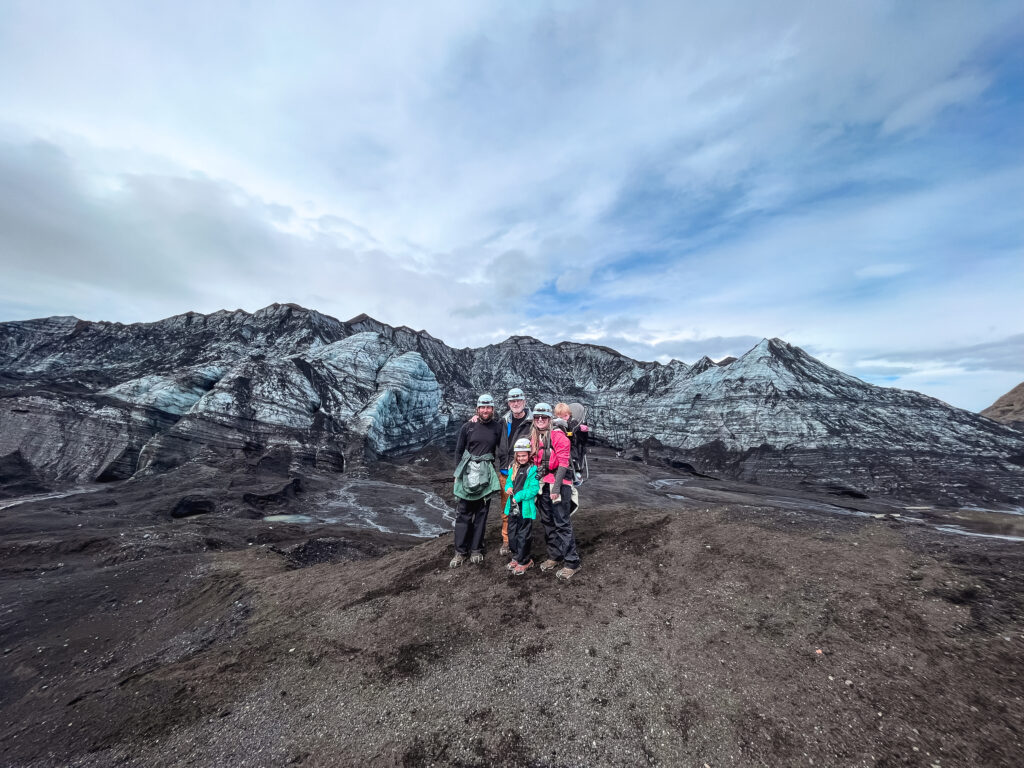 A family poses for a photo in front of the Katla Ice Caves