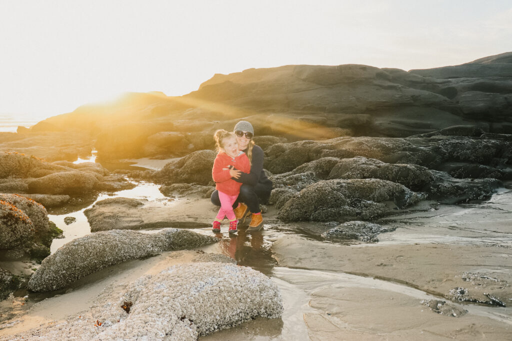 a mom and daughter smile on their oregon family vacation in the yachats tidepools