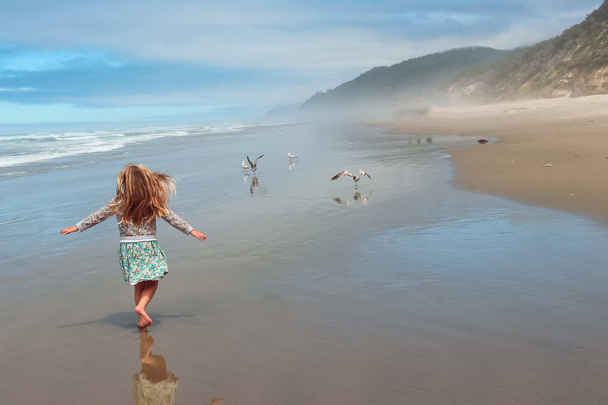 A girl running on Hobbit Beach during her Oregon Family Vacation