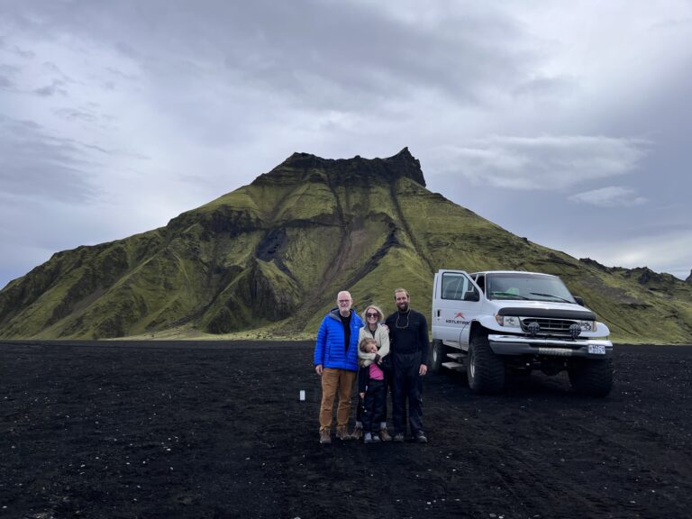 A family smiles by the Katla Ice Caves.