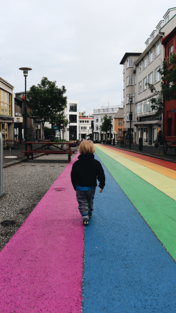 a young boy walks along rainbow road in Reykjavik