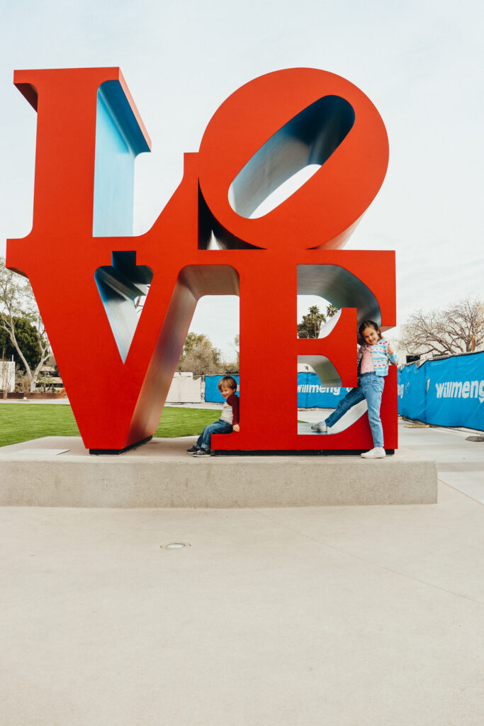 LOVE sculpture in downtown Scottsdale. Two children climb on the V and E.