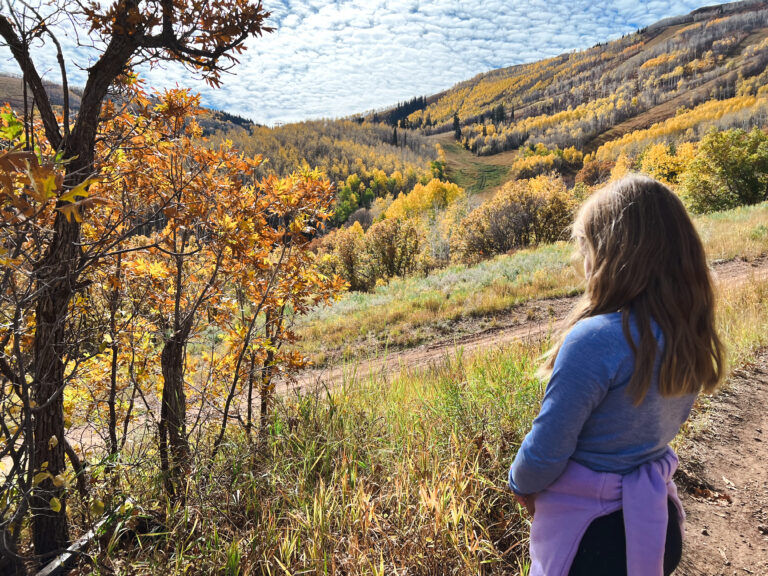 Park City in October, a young girl looks at the fall foliage on Jenni's trail.