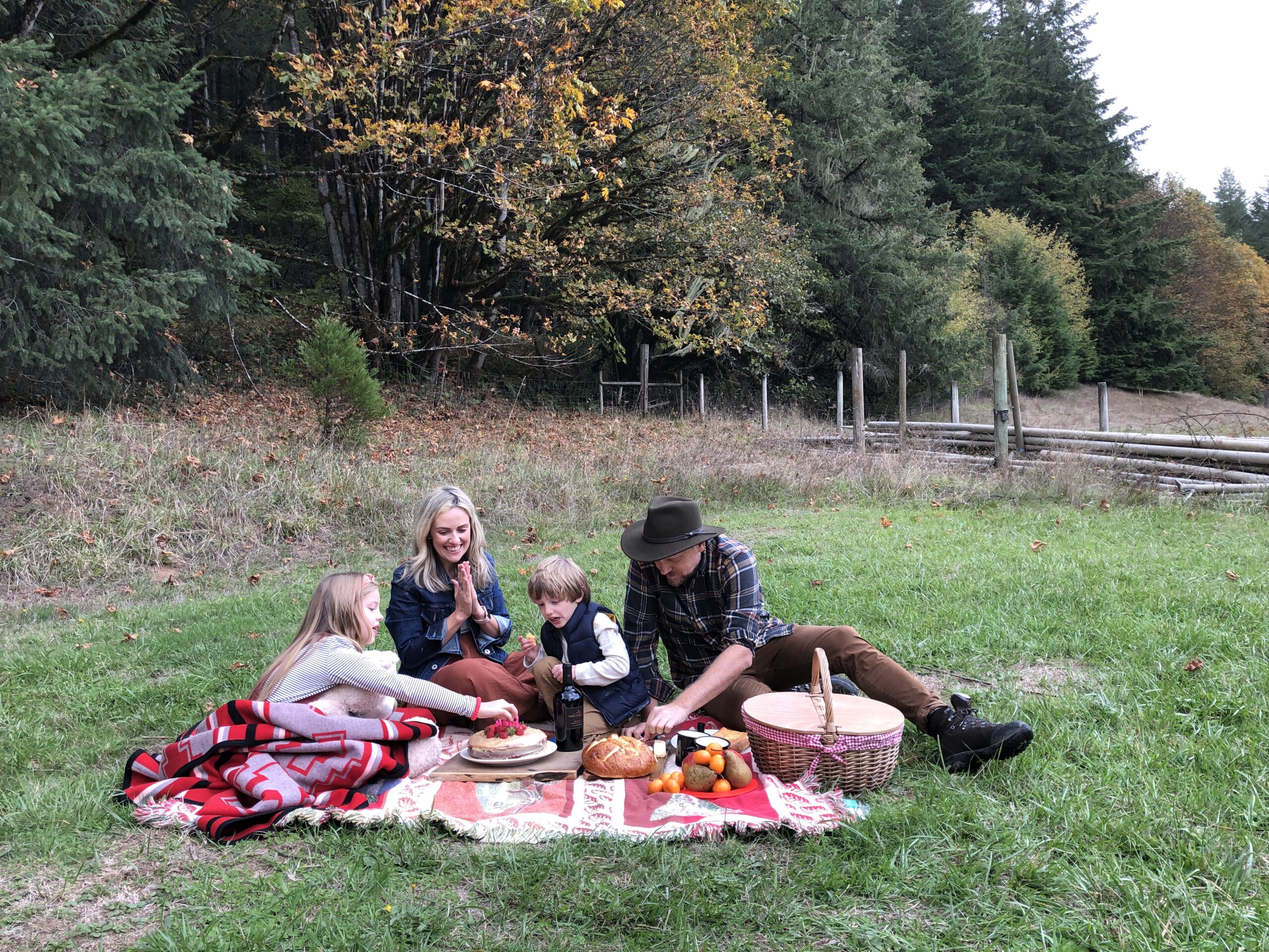 Adventure mom Priscila picnics with her family on a red checkered blanket.