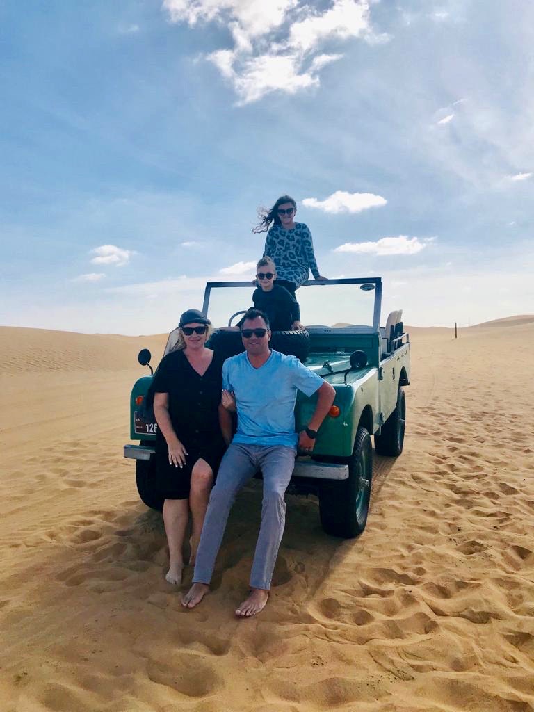 Family travel in the desert featuring a family of four on a jeep