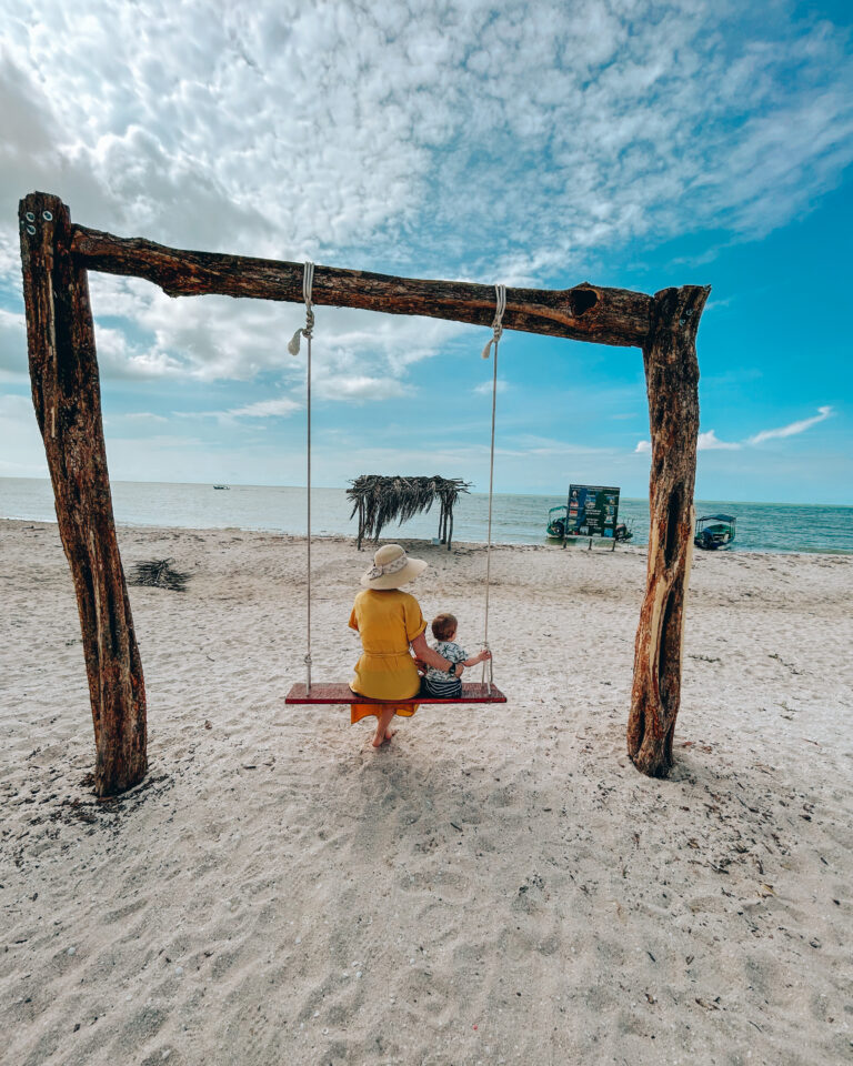 Toddler Travel Mum Dann on a beach swing with her toddler.